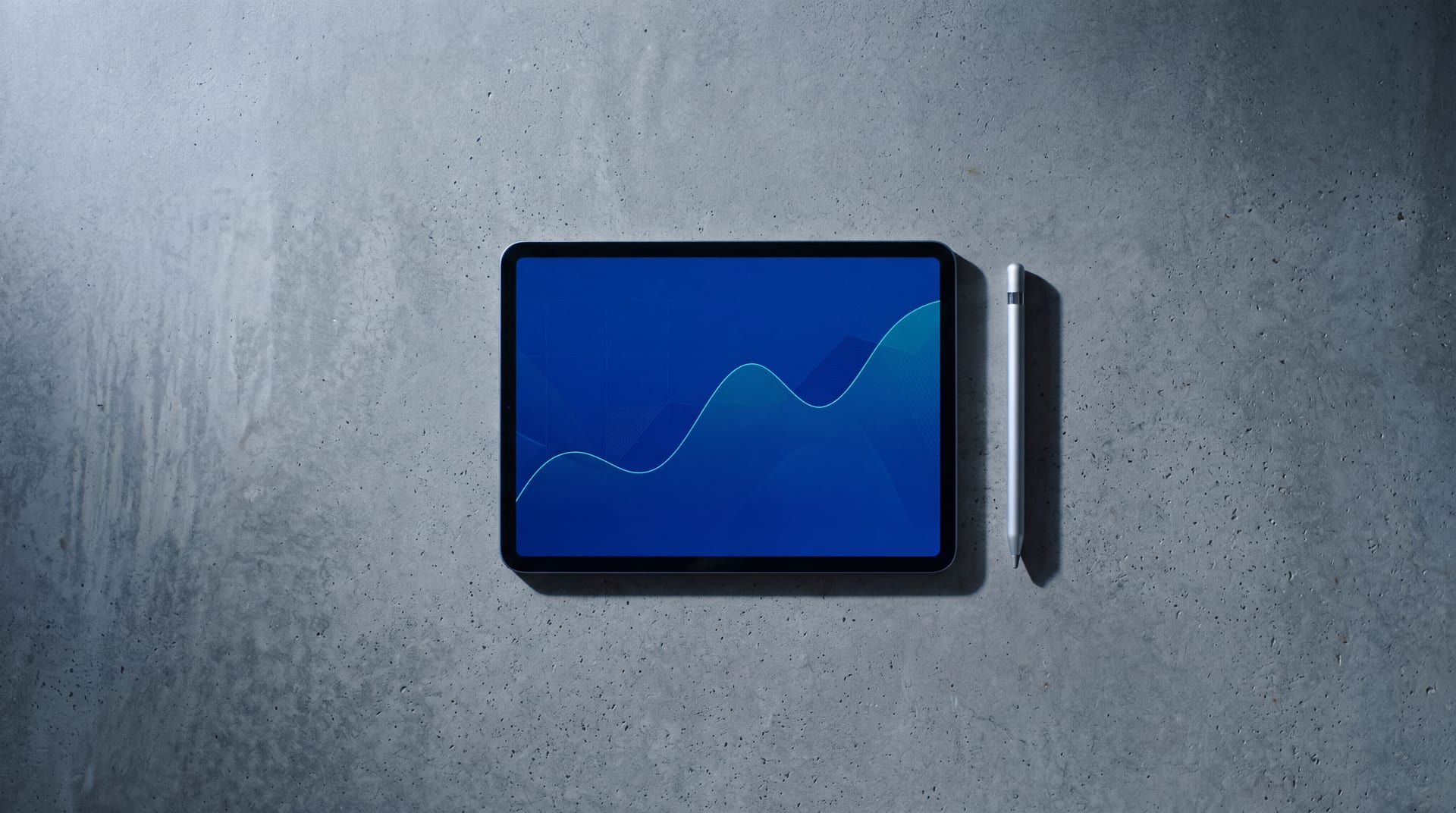 Single iPad on a polished concrete research desk, abstract market dashboard with a thin teal trend line on deep cobalt, brushed-aluminum stylus beside it